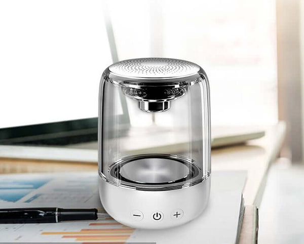 Vibrant Sound Bluetooth Speaker on a desk with a pen and charts, showcasing its sleek design and modern aesthetics.